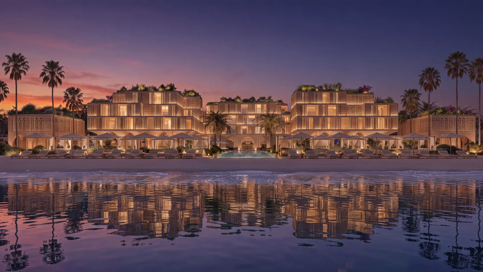 The beachfront building row reflected in the water at dusk